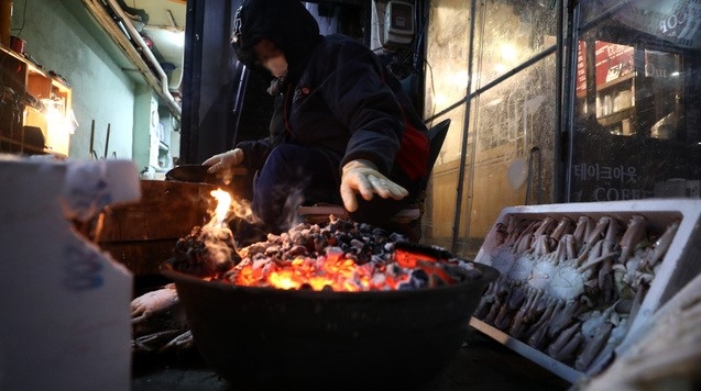 서울의 아침 최저 기온이 영하 18도를 보이며 최강 한파가 이어지고 있는 8일 오전 서울 중구 중림시장에서 한 상인이 모닥불을 피우며 장사 준비를 하고 있다.