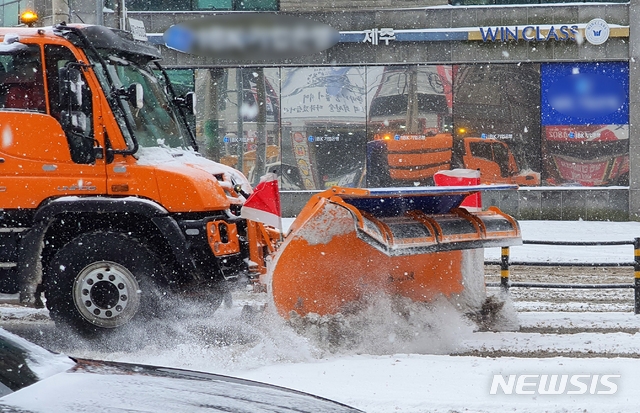 북극발 한파가 사흘째 기승을 부리고 있는 8일 오전 제주시 이도2동 구세무서 사거리 인근 도로에서 제설차가 부지런히 쌓인 눈을 치우고 있다.