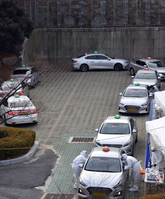 찾아가는 이동 선별검사소가 설치된 부산 연제구 부산아시아드주경기장 주차장을 찾은 택시 기사들이 11일 오전 드라이브스루 방식으로 코로나19 진단검사를 위한 검체를 채취하고 있다.
