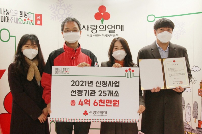 2021년 신청사업 선정기관 대표로 실로암시각장애인복지관 김미경 관장(오른쪽 두 번째)이 서울 사랑의열매 김용희 사무처장(왼쪽 두 번)과 배분금 전달판을 들고 기념촬영을 하고 있다.