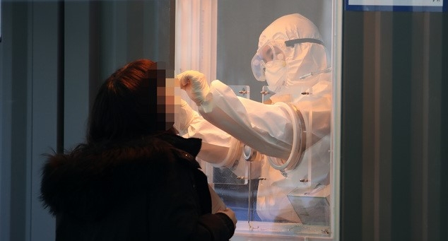 524명의 신규 코로나19 확진자가 발생한 14일 오전 서울역 광장에 설치된 중구 임시 선별검사소에서 의료진이 검체를 채취하고 있다.