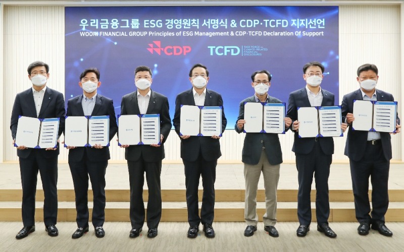 우리금융그룹은 15일 서울시 중구 소재 우리은행 본점 시너지홀에서 2021년 경영전략회의를 비대면으로 개최했다. 손태승 우리금융그룹 회장(사진 중앙)이 그룹사 CEO들과 함께 ESG경영원칙 서명식 및CDP(탄소정보공개프로젝트) ∙ TCFD(기후관련재무정보공개 권고안) 지지선언 기념촬영을 하고 있다. 왼쪽에서 세번째가 권광석 우리은행장, 네번째가 손태승 회장이다.