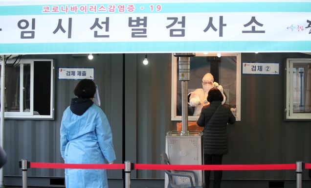 524명의 신규 코로나19 확진자가 발생한 14일 오전 서울역 광장에 설치된 중구 임시 선별검사소에서 의료진이 검체를 채취하고 있다.