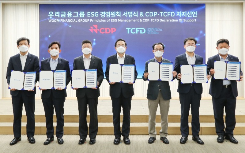 우리금융그룹은 15일 서울시 중구 소재 우리은행 본점 시너지홀에서 2021년 경영전략회의를 비대면으로 개최했다. 손태승 우리금융그룹 회장(사진 중앙)이 그룹사 CEO들과 함께 ESG경영원칙 서명식 및CDP(탄소정보공개프로젝트) ∙ TCFD(기후관련재무정보공개 권고안) 지지선언 기념촬영을 하고 있다.(사진=우리금융그룹 제공)