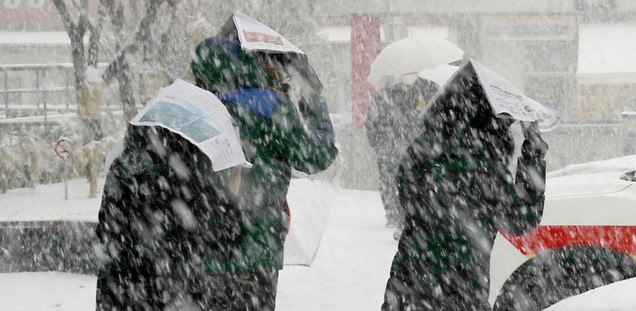 눈이 내리고 있는 지난 12일 오후 서울 중구 하나은행 앞에서 시민들이 신문지로 눈을 막으며 이동하고 있다.