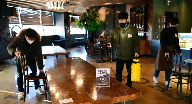 카페 매장 내 취식 허용을 하루 앞둔 17일 오후 대구 달서구 이월드 내 카페에서 직원들이 방역작업과 테이블 정리를 하고 있다.