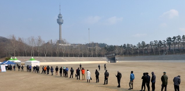 코로나19 신규 확진자가 54일 만에 첫 300명대를 기록한 18일 오후 대구 달서구 두류공원에 마련된 신종 코로나바이러스 감염증(코로나19) 임시선별검사소에서 시민들이 검체 채취를 하기 위해 줄을 서 있다.