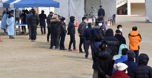 지난 18일 오후 대구 달서구 두류공원에 마련된 신종 코로나바이러스 감염증(코로나19) 임시선별검사소에서 시민들이 검체 채취를 하기 위해 줄을 서 있다.