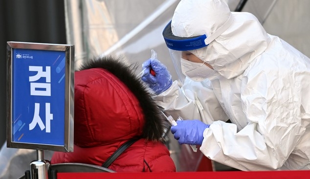 지난 19일 오후 경기도 수원시 팔달구 수원역에 마련된 코로나19 임시선별검사소에서 의료진이 검체 채취를 하고 있다.