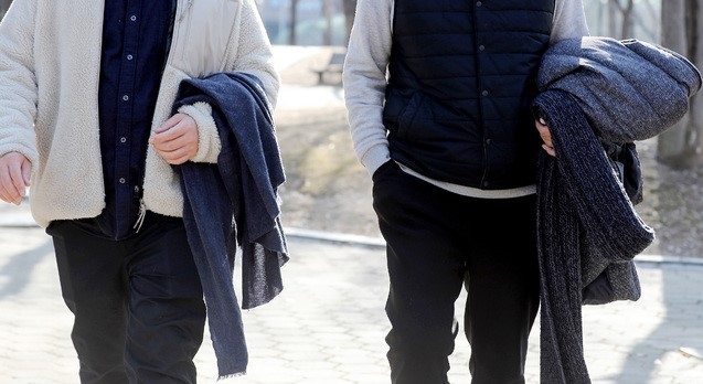 지난 20일 오후 서울 영등포구 여의도공원에서 시민들이 겉옷을 벗어 팔에 걸치고 있다. 