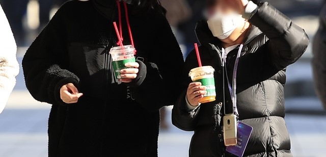 서울 지역 기온이 영상권을 회복한 지난 20일 오후 서울 청계천에서 아이스 커피를 손에 쥔 시민들이 걷고 있다.