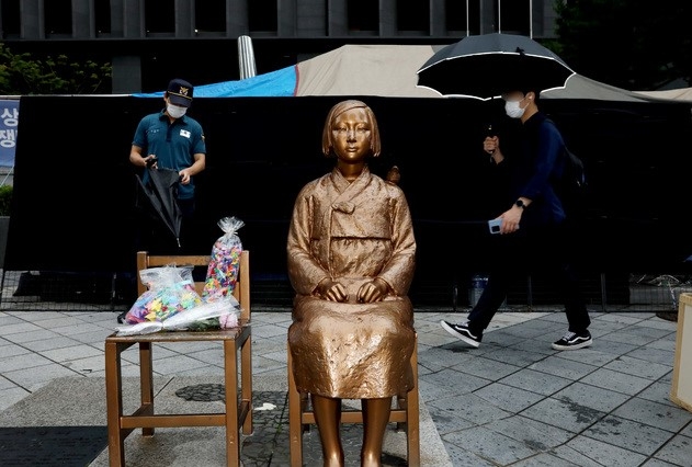 일본군'위안부' 피해자 기림의 날인 지난해 8월14일 오전 서울 종로구 옛 일본대사관 앞 평화의 소녀상 뒤로 시민들이 이동하고 있다.