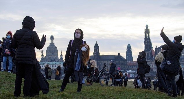 독일 동부 도시서 록다운 연장에 항의하는 미용 및 화장 관련 업주들이 21일 엘베 풀밭 모여 시위하고 있다. 한 여성 미용사가 마스크를 씌운 조발 인형을 들고 있다. 