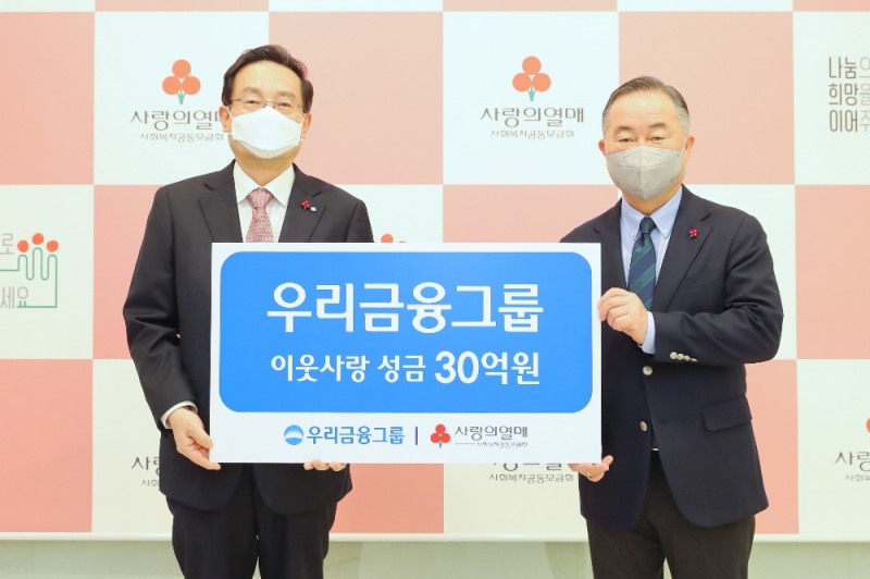 우리금융그룹은 25일 사회복지공동모금회에 성금 30억을 기탁했다. 손태승 우리금융그룹 회장(왼쪽)이 예종석 사회복지공동모금회 회장(오른쪽)과 기념촬영을 하고 있다.