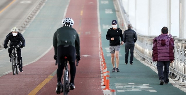 서울 낮 최고기온이 13도까지 오르며 포근한 날씨가 이어지는 지난 25일 서울 서초구 잠수교에서 시민들이 자전거 및 러닝을 하고 있다.