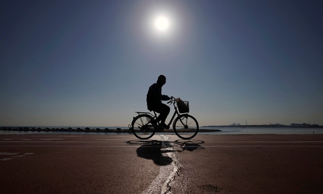 21일 일본 도쿄에서 코로나19 예방을 위해 마스크를 쓴 한 남성이 자전거를 타고 지나가고 있다.