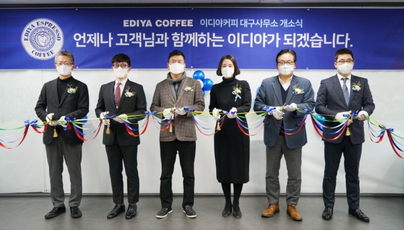 26일 대구광역시 동구에 위치한 이디야커피 대구사무소에서 열린 개소식에서 이디야커피 문창기 회장(왼쪽에서 세번째)과 신유호 부사장(왼쪽 첫번째), 김남엽 부사장(오른쪽 두번째)을 비롯한 관계자들이 테이프를 커팅하고 있다.