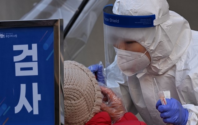 신종 코로나바이러스 감염증(코로나19) 신규 확진자가 이틀 연속 300명대를 기록한 19일 오후 경기도 수원시 팔달구 수원역에 마련된 코로나19 임시선별검사소에서 의료진이 검체 채취를 하고 있다.