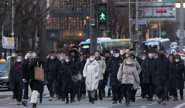 서울 아침 최저기온이 영하 13도에 이르는 등 전국에 한파특보가 내려진 지난 19일 서울 광화문 사거리에서 옷을 두텁게 입은 시민들이 출근하고 있다.