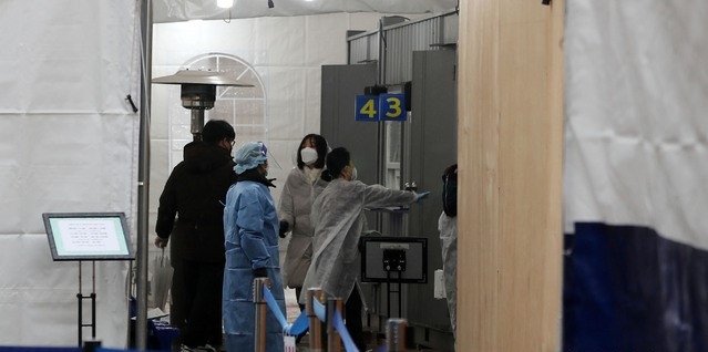 코로나19 신규 확진자가 다시 300명대를 기록한 26일 오전 서울 영등포보건소 선별진료소에서 시민들과 의료진이 검사를 준비하고 있다.