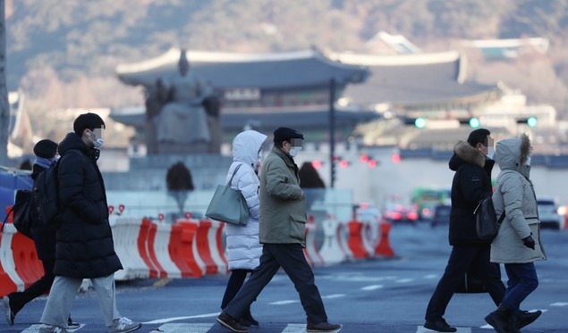 서울 아침 최저기온이 영하 13도에 이르는 등 전국에 한파특보가 내려진 지난 19일 서울 광화문 사거리에서 옷을 두텁게 입은 시민들이 출근하고 있다.