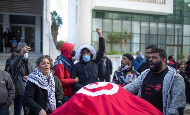 코로나19로 전국 봉쇄가 시행 중인 14일(현지시간) 튀니지 수도 튀니스에서 소수 인원이 모여 독재자 벤 알리 대통령 추출 10주년을 기념하고 있다. 튀니지는 '아랍의 봄'을 촉발했던 민중 봉기 10주년을 맞았으나 코로나19 여파로 아무런 기념행사도 열리지 않았다.