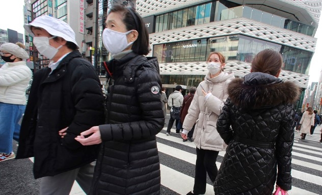 지난 26일 일본 도쿄의 긴자 쇼핑거리에서 신종 코로나바이러스 감염증(코로나19) 예방을 위해 마스크를 쓴 시민들이 건널목을 건너고 있다.