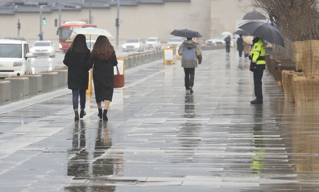 서울 지역에 비가 내리고 있는 지난 21일 오후 서울 종로구 광화문광장에서 우산을 쓴 시민들이 걷고 있다.