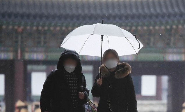 지난 21일 오후 서울 종로구 경복궁에서 우산을 쓴 시민들이 걷고 있다.