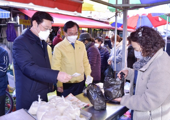 이용섭 광주광역시장이 지난 8일 오후 설 명절을 앞두고 광산구 송정5일시장을 찾아 코로나19로 어려움을 겪고 있는 상인들을 격려하며 제수용품을 구매하고 있다./사진=광주시