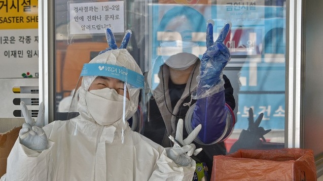 대구 지역 신종 코로나바이러스 감염증(코로나19) 확진자가 21명으로 집계된 8일 오후 대구 동구 보건소 코로나19 선별진료소에서 의료진들이 미소를 보이며 손가락 브이를 표시하고 있다.