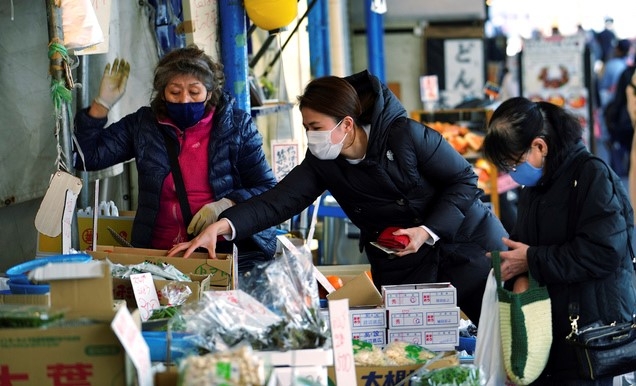 1일 일본 도쿄의 한 상점에서 코로나19 예방을 위해 마스크를 쓴 사람들이 채소를 사고 있다.