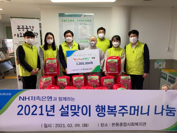 NH저축은행 최광수(왼쪽 세 번째) 대표와 나눔봉사단이 9일, 본동사회복지관에 방문해 설맞이 행복주머니를 전달한 뒤 본동사회복지관 법현 복지관장(왼쪽 네 번째)과 함께 기념촬영을 하고 있다 / 사진 제공 = NH저축은행