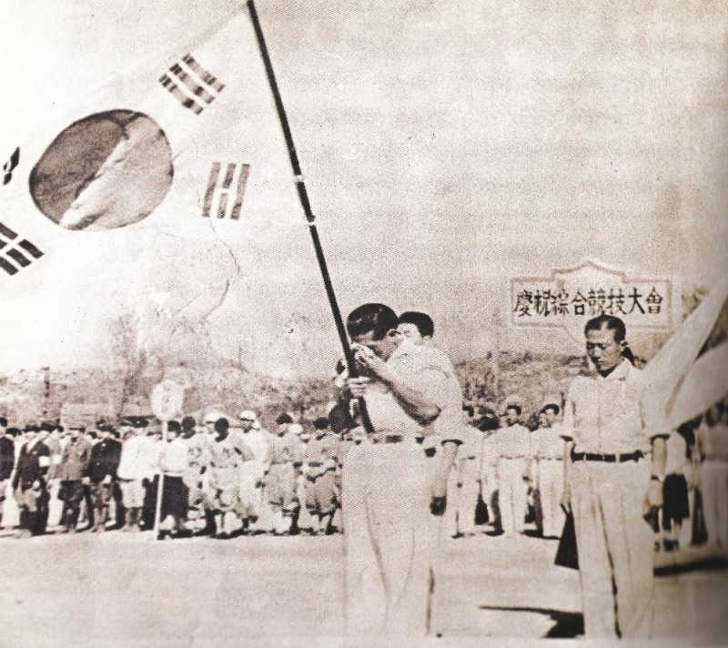 광복 후 처음으로 열린 자유해방 경축 종합 경기대회 개회식에서 태극기를 든 손기정이 눈물을 흘리며 감격에 겨워하고 있다.