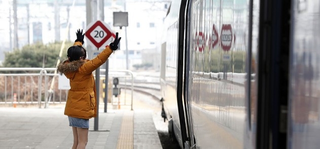 설 연휴를 하루 앞둔 10일 오후 서울역에서 한 시민이 열차에 탑승한 귀성객에게 손을 흔들며 배웅하고 있다.