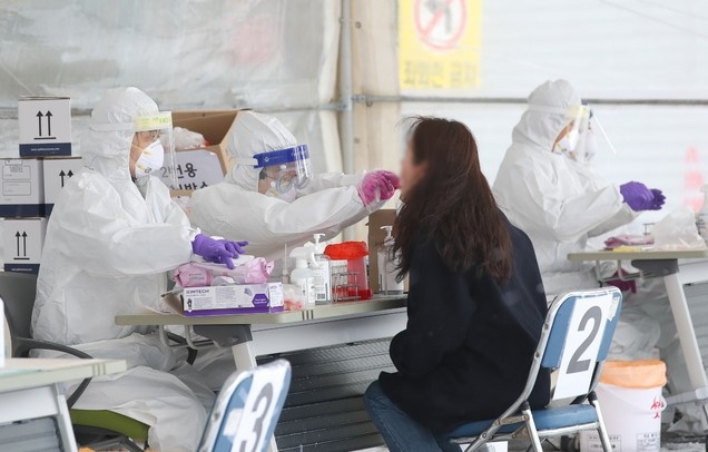 제주시보건소 내 주차장 한 켠에 마련된 코로나19 선별진료소에서 의료진들이 검체 채취를 하고 있다.