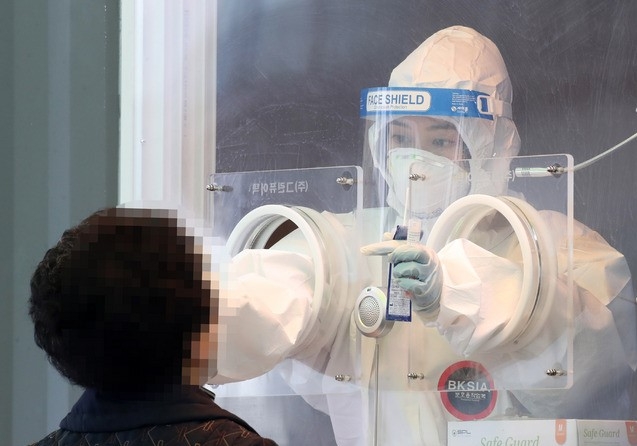 신종 코로나바이러스 감염증(코로나19) 확진자가 326명으로 이틀 연속 300명대로 집계된 14일 오전 서울 중구 서울역광장에 마련된 코로나19 중구임시선별검사소에서 의료진이 검체 채취를 하고 있다.