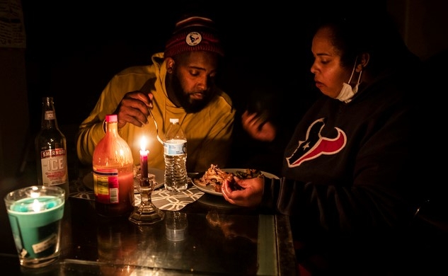 16일(현지시간) 미국 텍사스 글렌우드 지역의 한 가족이 촛불을 켠 채 식사를 하고 있다. 미국 남부를 강타한 한파가 텍사스주(州)에서는 전력 수요가 급증하며 블랙아웃 사태가 불거졌다.