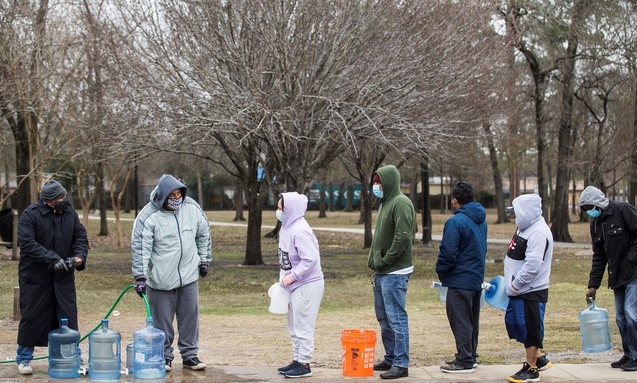 18일(현지시간) 미 텍사스주 휴스턴의 헤이든 공원에서 주민들이 수돗물을 받고 있다. 주 당국은 7백만 주민에게 수돗물은 반드시 끓여 먹을 것을 당부했다. 사상 유례없는 한파로 텍사스 지역 주민들은 전기와 물이 끊긴 채 영하의 날씨 속에서 사투를 벌이고 있다.
