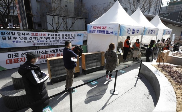 서울 광진구 '건대 맛의 거리' 및 건대입구역 주변 음식점 상인과 종업원 등이 23일 청춘뜨락에 마련된 임시선별검사소를 찾아 코로나19 선제검사를 하고 있다.