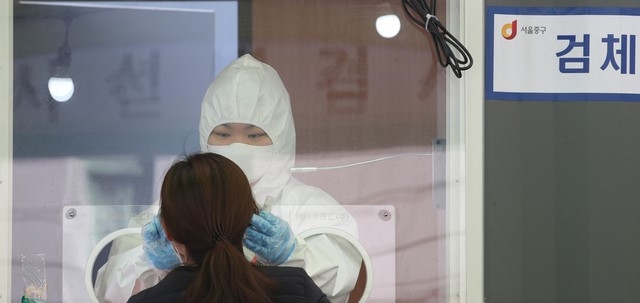 2월의 마지막 주말인 27일 서울 중구 서울역 신종 코로나바이러스 감염증(코로나19) 임시검사소에서 의료진이 시민들의 검체를 체취하고 있다. 