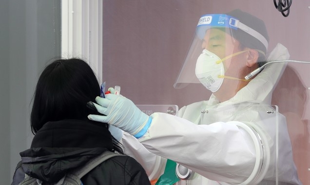 지난 4일 오전 서울 중구 서울역 광장에 마련된 코로나19 임시 선별검사소에서 의료진이 검체를 채취하고 있다. 