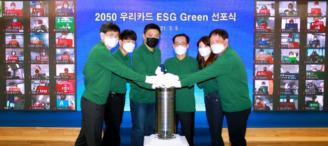 김정기 사장(왼쪽에서 네번째)과 최현수 노조위원장(왼쪽에서 세번째), 이상우 상근감사위원(왼쪽 첫번째), 허정진 부사장(오른쪽 맨끝), 임직원 대표 2명이 실천 과제가 담긴 그린 선언문을 타임캡슐에 넣고 있다. / 제공 = 우리카드