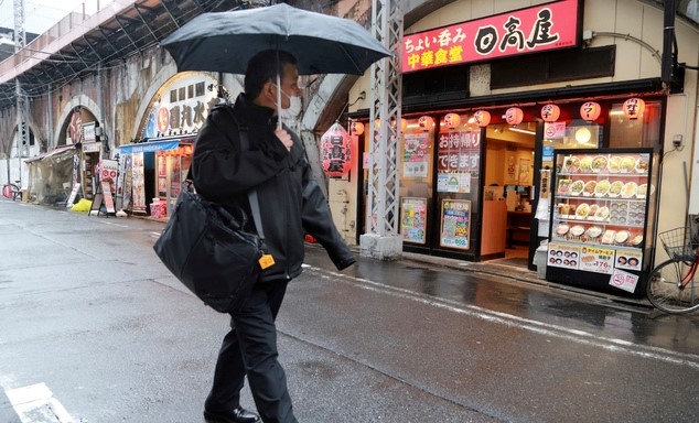 8일 일본 도쿄에서 코로나19 확산 방지를 위해 마스크를 쓴 한 시민이 술집과 식당이 즐비한, 거의 텅 빈 거리를 걷고 있다. 일본 수도권은 오늘부터 21일까지 코로나19 확산 억제를 위한 긴급사태 연장에 들어간다. 