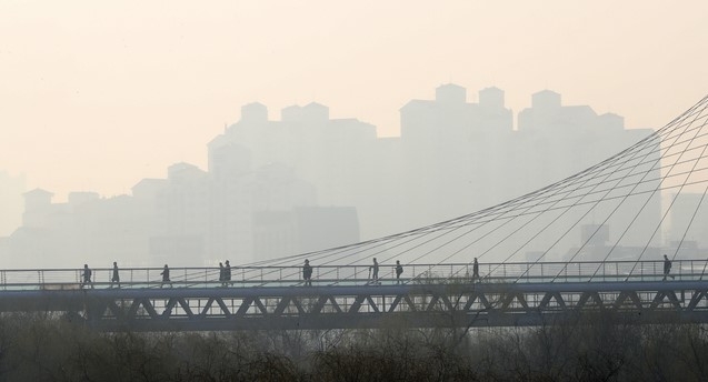 미세먼지와 초미세먼지 농도가 치솟으며 수도권 미세먼지 비상저감조치가 시행된 지난 11일 오전 서울 영등포구 문화다리 위로 출근하는 시민들과 빌딩들이 흐릿하게 보이고 있다.