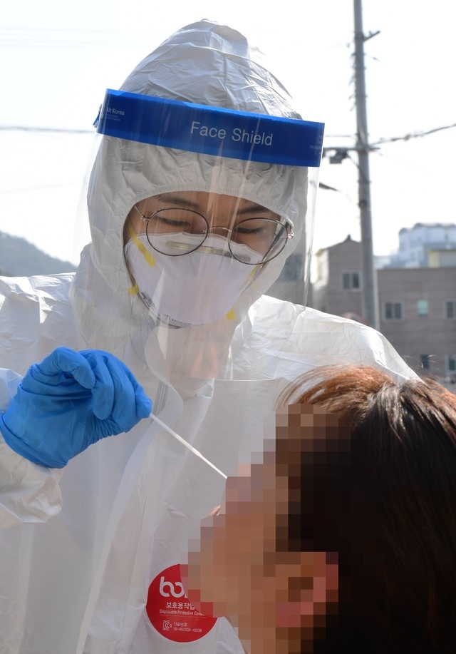 주말인 14일 오전 경남 남해군보건소 의료진인 남해읍 향교 앞 광장에 차려진 선별진료소에서 주민들을 대상으로 코로나19 검체 채취를 하고 있다. 이날 남해군은 지난 12일과 13일 코로나19 확진자가 집중적으로 발생한 A마을 주민(검사희망자)들을 대상으로 선제검사를 실시했다.