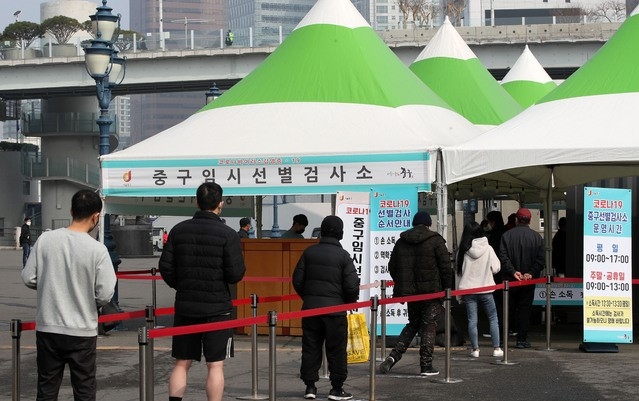 지난 14일 오전 서울역 광장에 마련된 중구 임시 선별검사소에 시민들이 검사를 받기 위해 줄을 서고 있다.