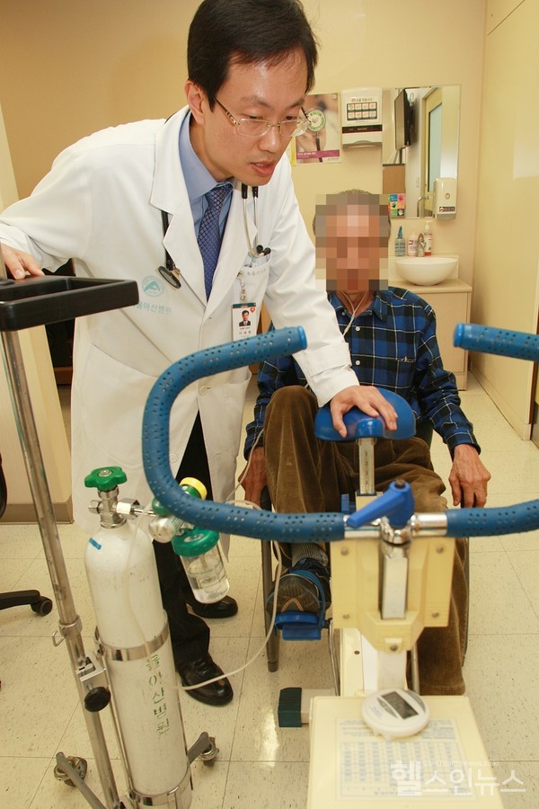 이세원서울아산병원호흡기내과교수가폐질환환자에게실내자전거를이용한호흡재활운동을지도하고있다
