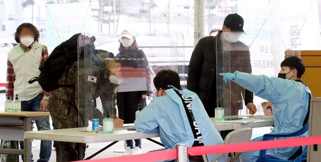 지난 15일 오후 서울 용산구 서울역 앞에 마련된 임시선별검사소에서 시민들이 문진표를 작성하고 있다.