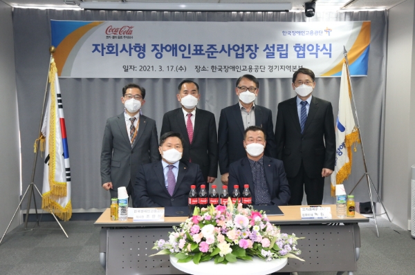 한국장애인고용공단과 코카콜라음료는 지난 17일 오후 장애인고용공단 경기지역본부에서 '자회사형 장애인 표준사업장' 설립을 위한 협약식을 체결했다. 앞줄 왼쪽부터 조향현 장애인고용공단 이사장, 박헌영 코카콜라음료 전무. 사진=코카콜라음료 제공